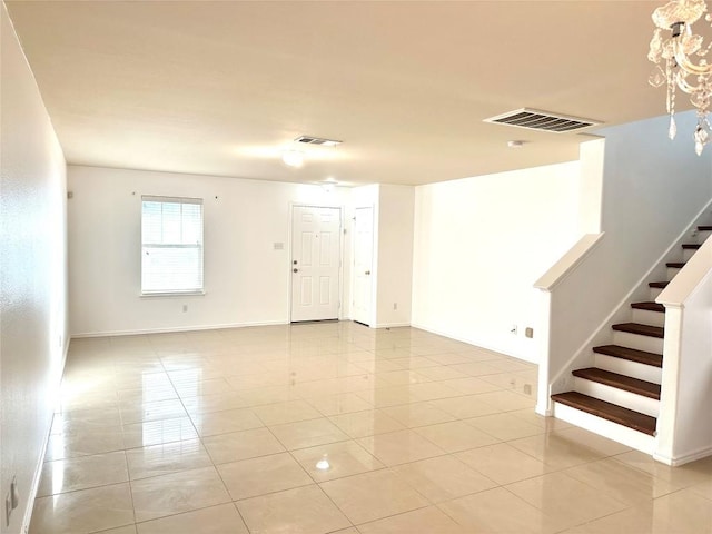 spare room featuring stairs, light tile patterned floors, visible vents, and baseboards