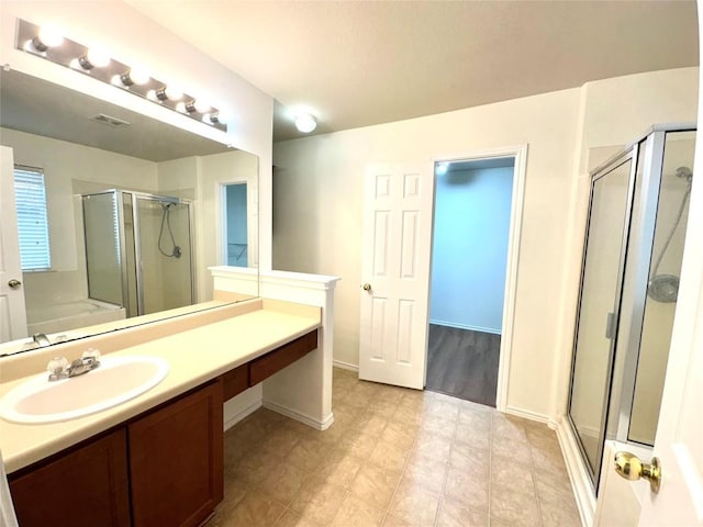 full bath featuring visible vents, a stall shower, vanity, baseboards, and a bath