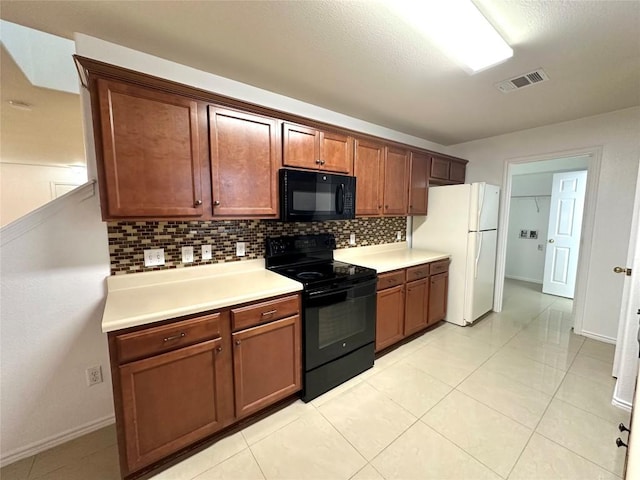 kitchen featuring light tile patterned floors, visible vents, light countertops, black appliances, and tasteful backsplash