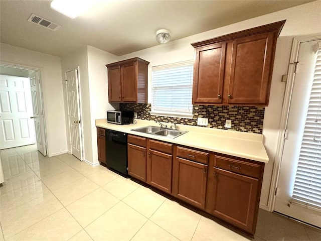 kitchen with visible vents, dishwasher, stainless steel microwave, light countertops, and a sink