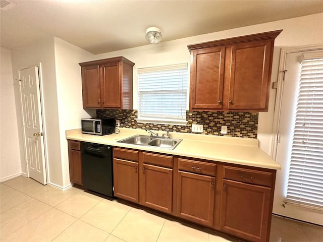 kitchen featuring black dishwasher, light countertops, stainless steel microwave, and a sink