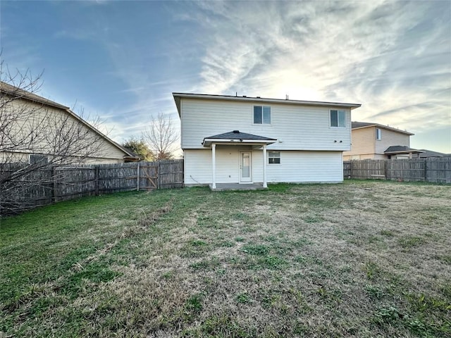 back of property featuring a fenced backyard and a yard