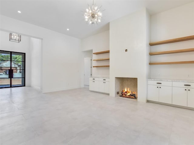 unfurnished living room with recessed lighting, a warm lit fireplace, and a notable chandelier