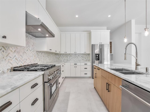 kitchen featuring high end appliances, tasteful backsplash, a sink, light stone countertops, and under cabinet range hood