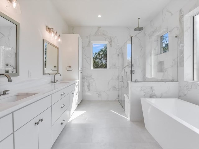 full bathroom featuring a soaking tub, a sink, a marble finish shower, and double vanity