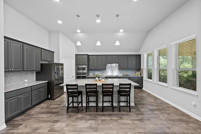 kitchen featuring dark wood-style flooring, a large island, stainless steel appliances, gray cabinets, and under cabinet range hood