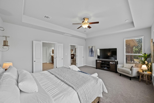 bedroom featuring a tray ceiling, visible vents, ceiling fan, and carpet flooring