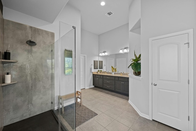 full bath featuring double vanity, visible vents, a walk in shower, baseboards, and tile patterned floors