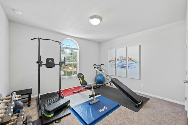 workout area featuring carpet and baseboards