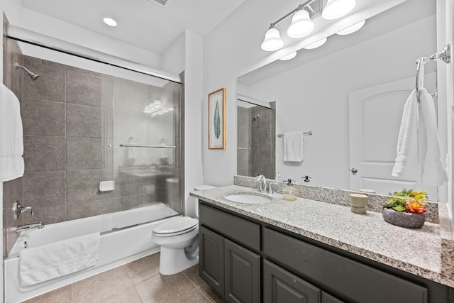 full bathroom with bath / shower combo with glass door, vanity, tile patterned flooring, and toilet