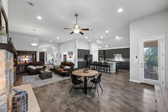 dining space featuring arched walkways, recessed lighting, ceiling fan with notable chandelier, dark wood-style flooring, and visible vents