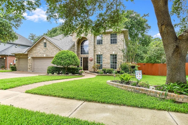 view of front of home featuring driveway, an attached garage, fence, a front yard, and brick siding