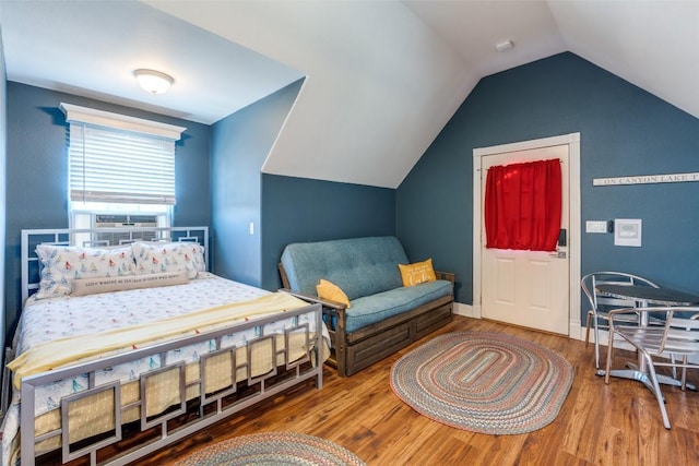 bedroom featuring vaulted ceiling, baseboards, and wood finished floors