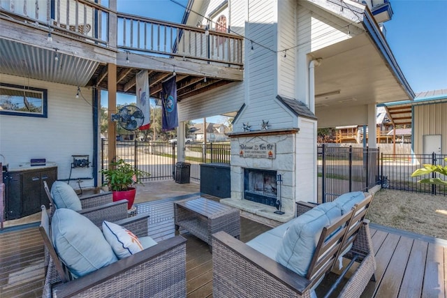 wooden terrace with an outdoor living space with a fireplace and fence