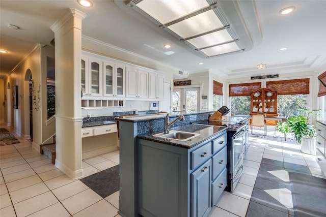 kitchen featuring light tile patterned floors, ornamental molding, white cabinetry, a sink, and stainless steel range with electric stovetop
