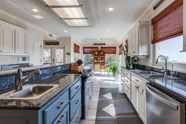 kitchen featuring appliances with stainless steel finishes, french doors, white cabinets, and a sink