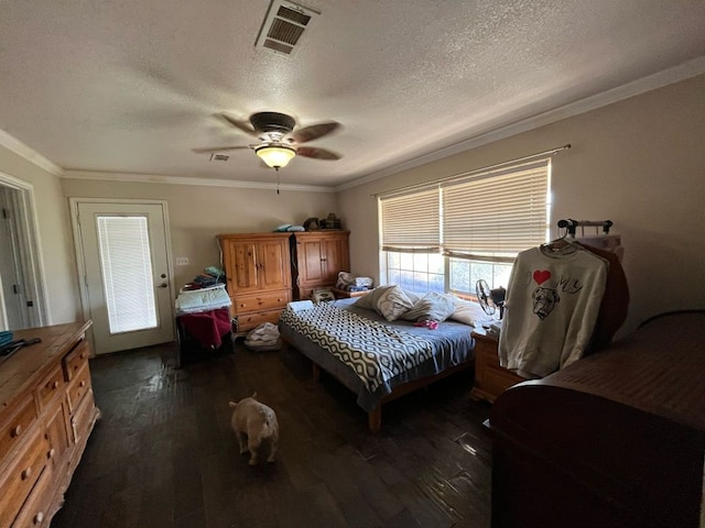 bedroom with ceiling fan, a textured ceiling, visible vents, dark wood finished floors, and crown molding