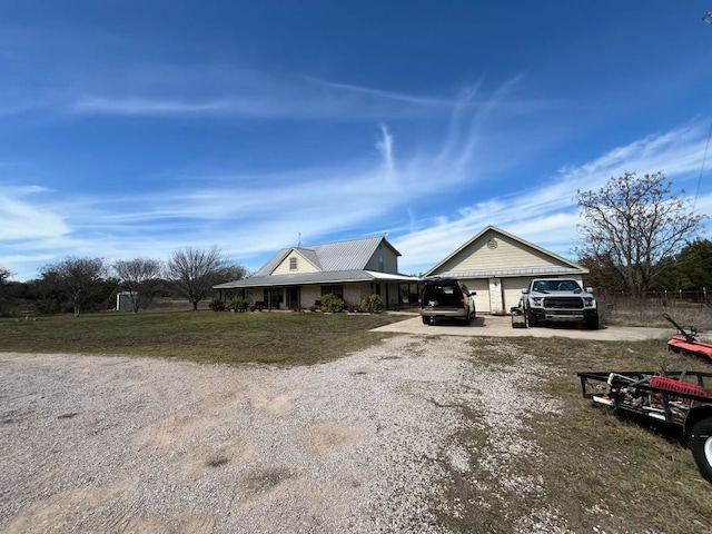 view of front facade featuring dirt driveway, a front lawn, and a garage