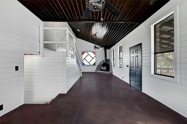 corridor with concrete flooring, wooden ceiling, and lofted ceiling