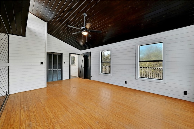 interior space featuring lofted ceiling, ceiling fan, wood walls, wood finished floors, and wooden ceiling