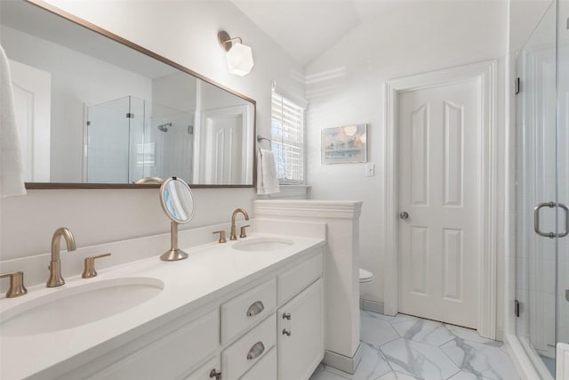 bathroom featuring marble finish floor, lofted ceiling, a sink, and a stall shower