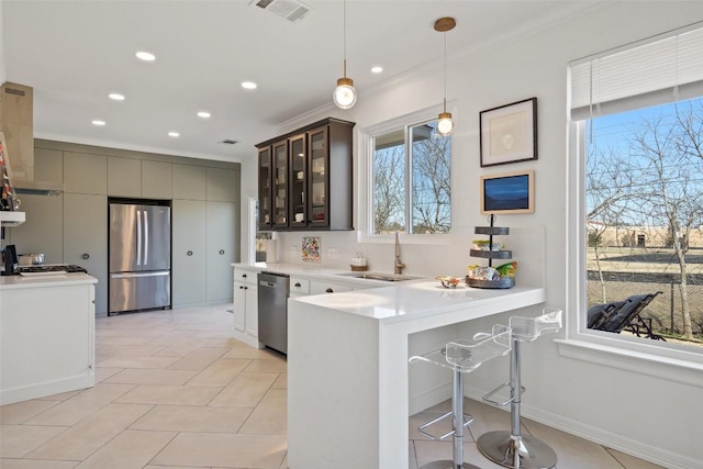 kitchen featuring light countertops, a sink, stainless steel appliances, visible vents, and extractor fan