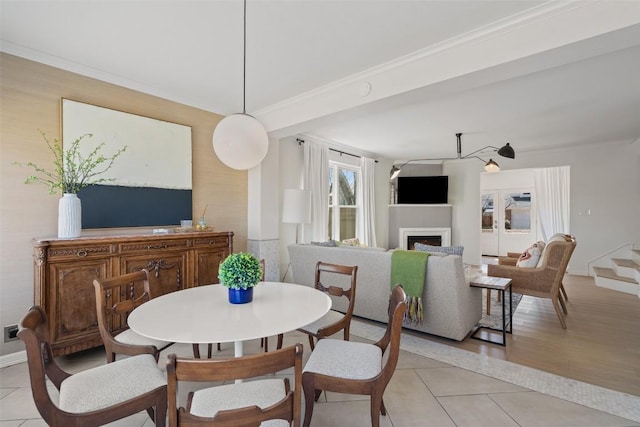 dining space featuring light tile patterned flooring, a fireplace, and ornamental molding