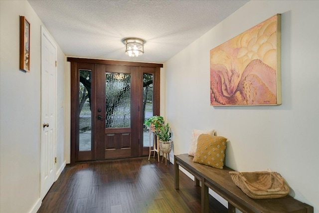 foyer entrance with a textured ceiling and wood finished floors