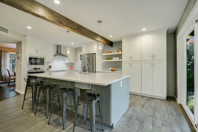 kitchen featuring open shelves, stainless steel appliances, white cabinetry, light countertops, and wall chimney exhaust hood