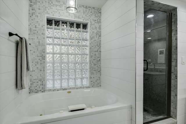 bathroom featuring a jetted tub and a stall shower