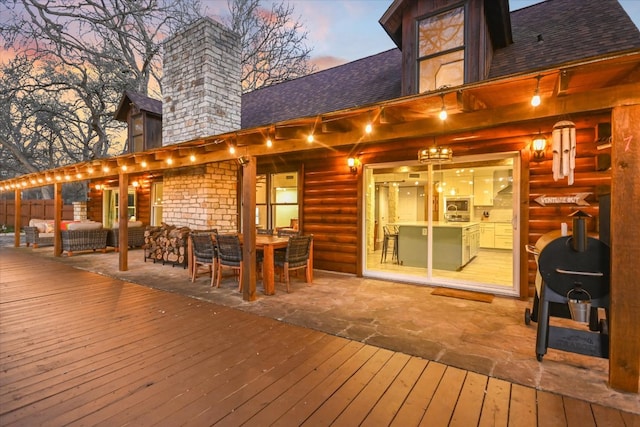 deck at dusk featuring outdoor dining space