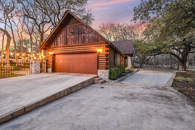exterior space with log exterior, roof with shingles, fence, and driveway