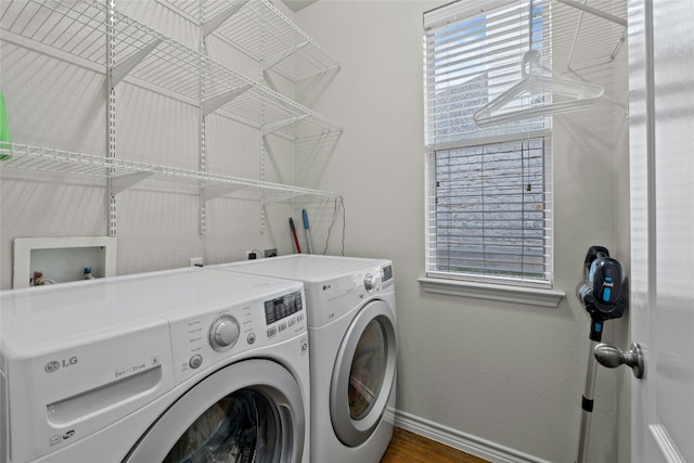 washroom with laundry area, baseboards, washer and clothes dryer, and dark wood finished floors