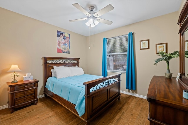 bedroom with a ceiling fan, baseboards, and wood finished floors