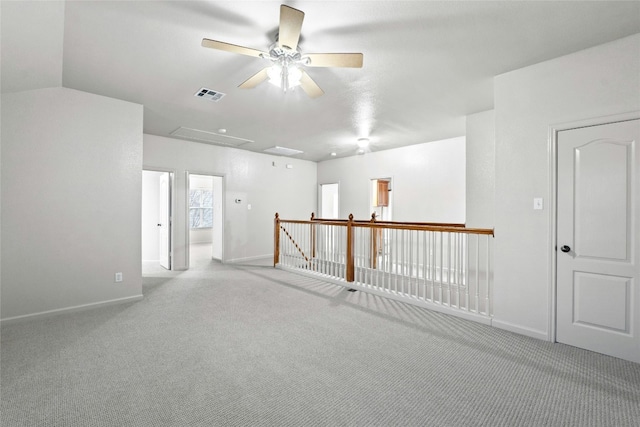 empty room with carpet floors, visible vents, baseboards, and a ceiling fan