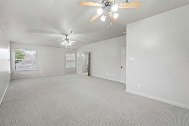 unfurnished room with baseboards, visible vents, light colored carpet, ceiling fan, and vaulted ceiling