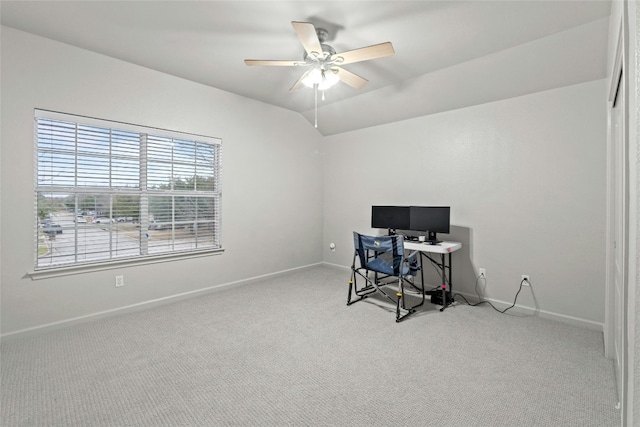 carpeted office space with baseboards, vaulted ceiling, and a ceiling fan