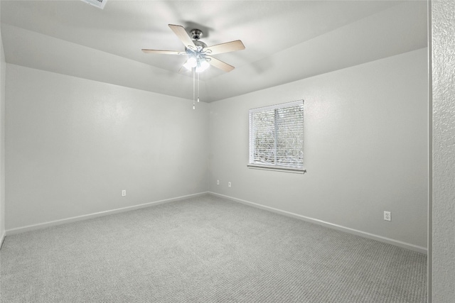 carpeted empty room featuring baseboards and a ceiling fan