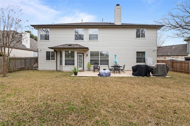 rear view of house with a fenced backyard, a patio, a chimney, and a lawn