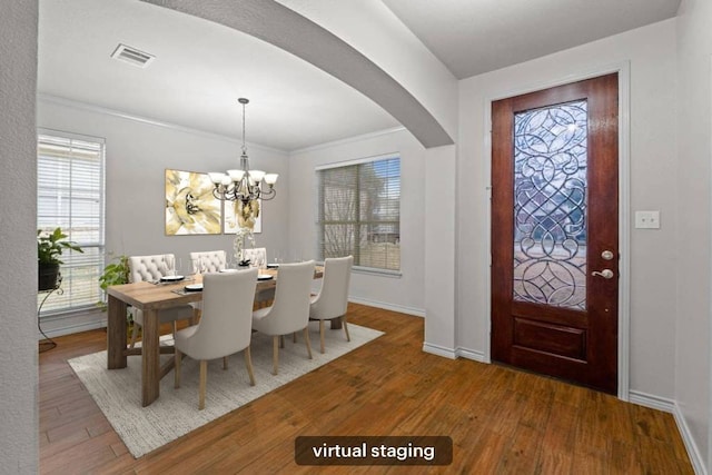 1532 Homewood Cir, Round Rock, TX 78665 - dining room with arched walkways, wood finished floors, baseboards, a chandelier, and crown molding