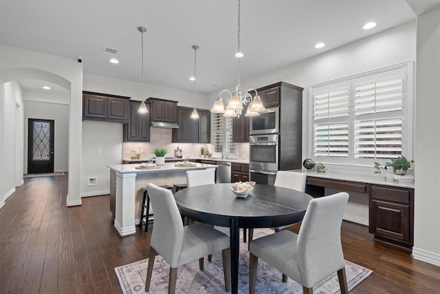 dining area featuring arched walkways, recessed lighting, visible vents, dark wood-type flooring, and baseboards