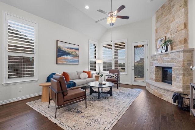 living room featuring a fireplace, dark wood finished floors, lofted ceiling, a ceiling fan, and baseboards