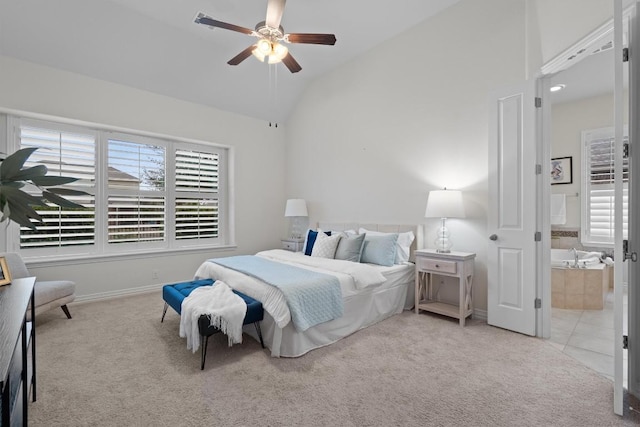 bedroom featuring light carpet, light tile patterned floors, baseboards, and ensuite bathroom