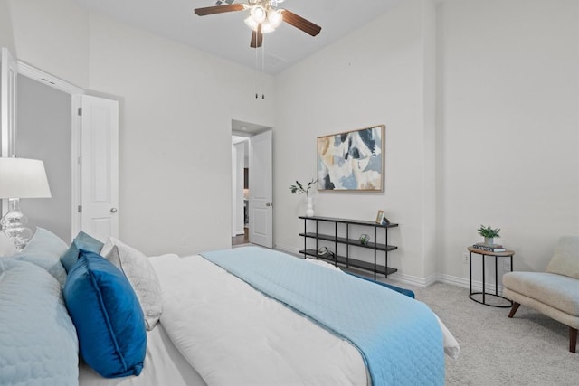 bedroom featuring ceiling fan, carpet flooring, a towering ceiling, and baseboards