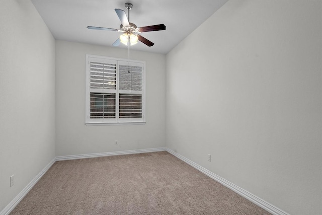 empty room with carpet, a ceiling fan, and baseboards