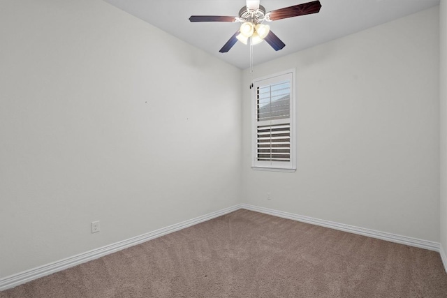 carpeted spare room featuring a ceiling fan and baseboards