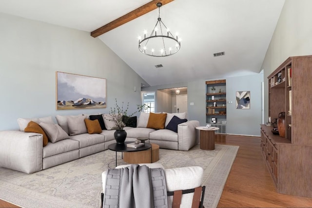 living area with visible vents, a chandelier, beamed ceiling, light wood-style floors, and high vaulted ceiling