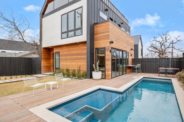 rear view of property featuring fence, a deck, and stucco siding