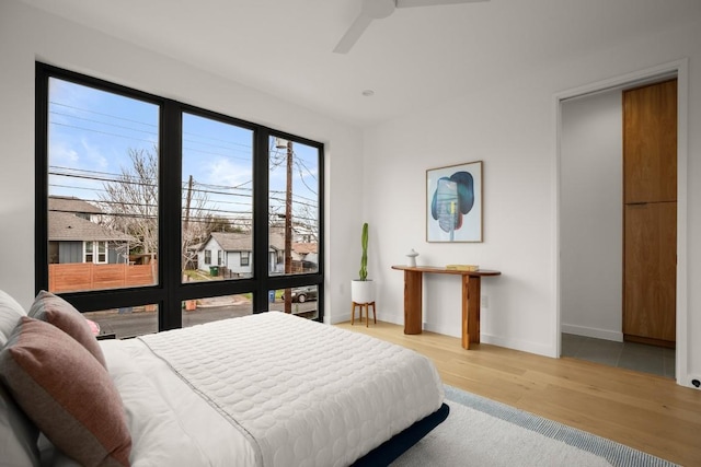 bedroom featuring ceiling fan, wood finished floors, and baseboards