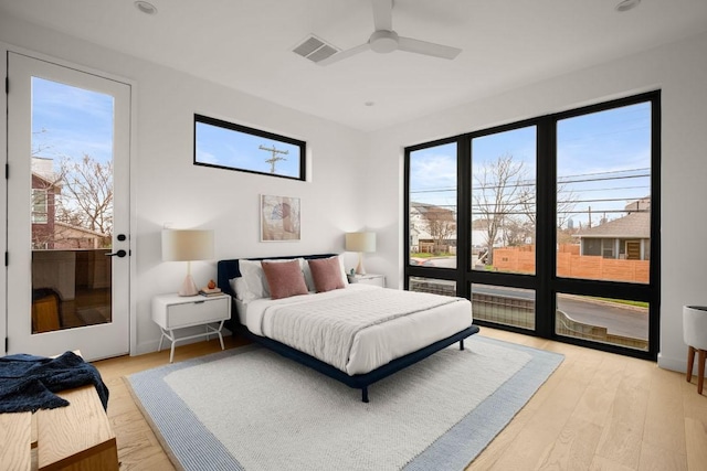 bedroom featuring ceiling fan, light wood finished floors, visible vents, and access to exterior